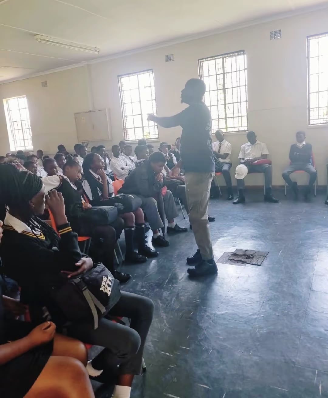 SSF facilitator speaking to high school learners in a classroom